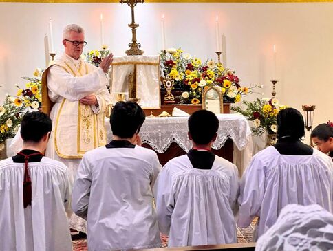 Priest giving a blessing to the altar servers